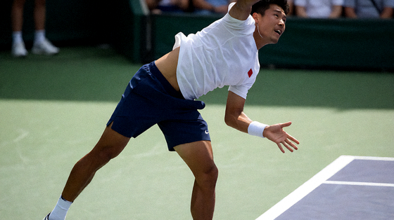 网球选手在硬地赛场发球的比赛画面